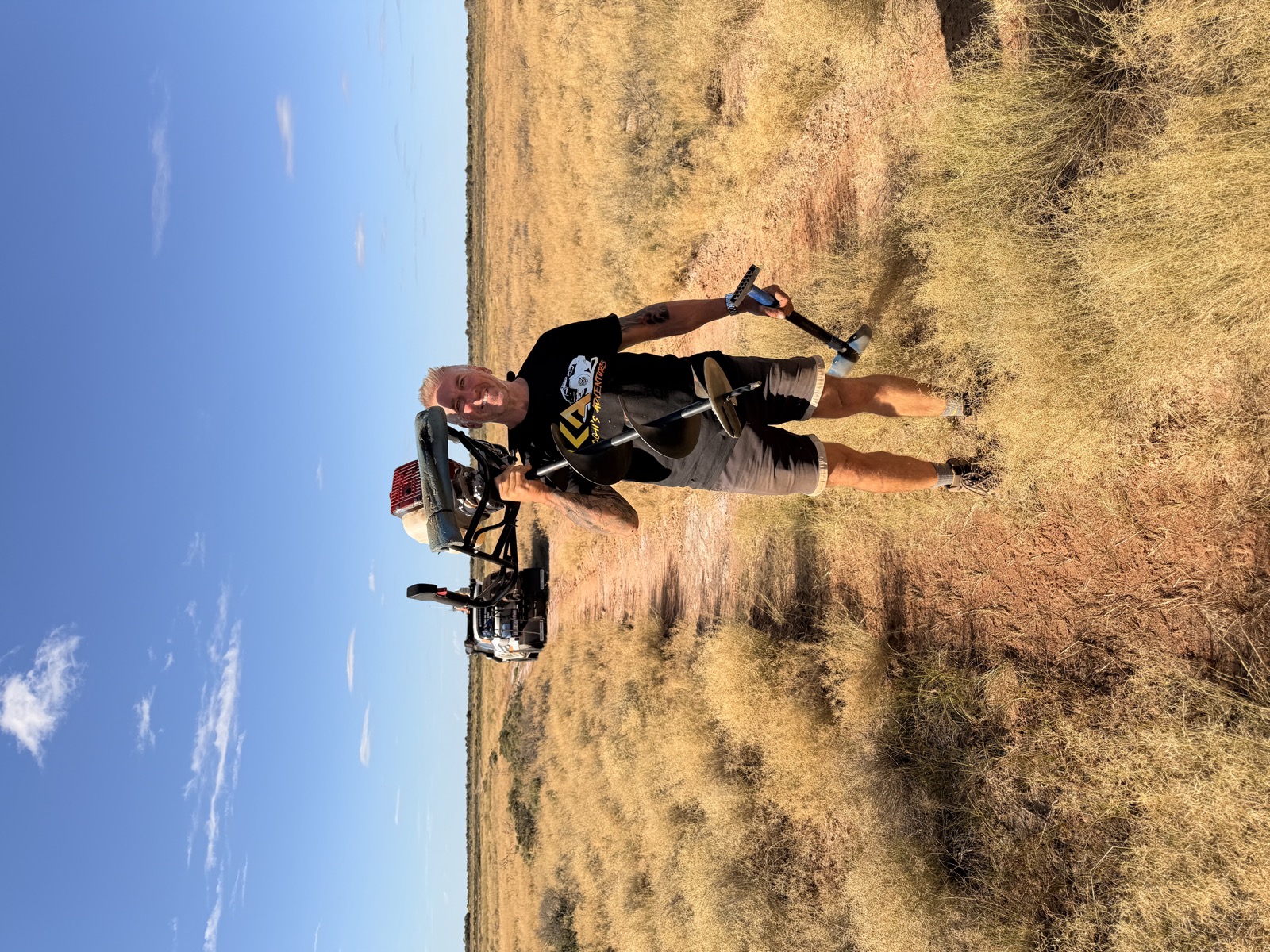 Standing in spinifex holding a petrol auger