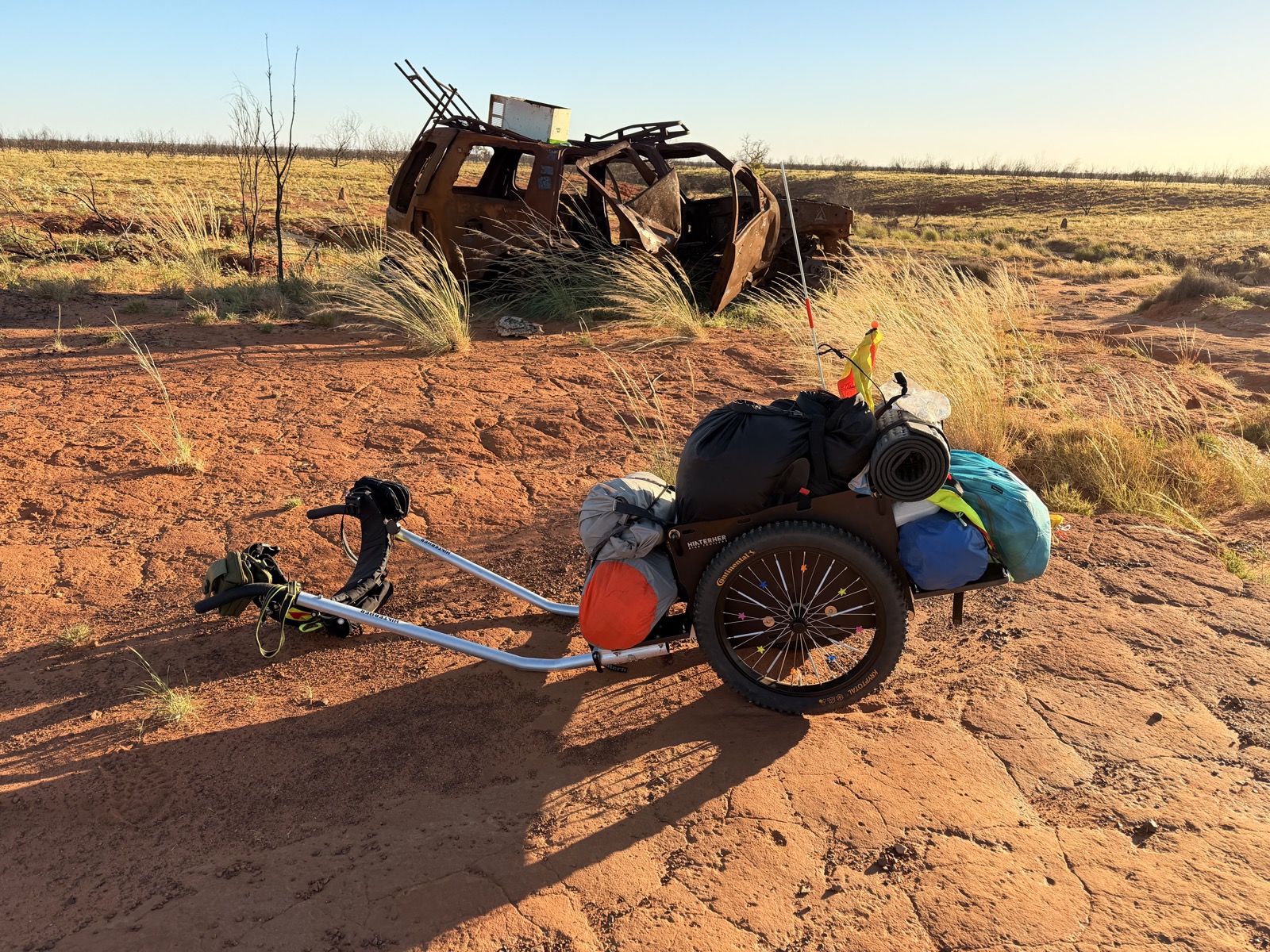 A burnt-out vehicle wreck beside the track