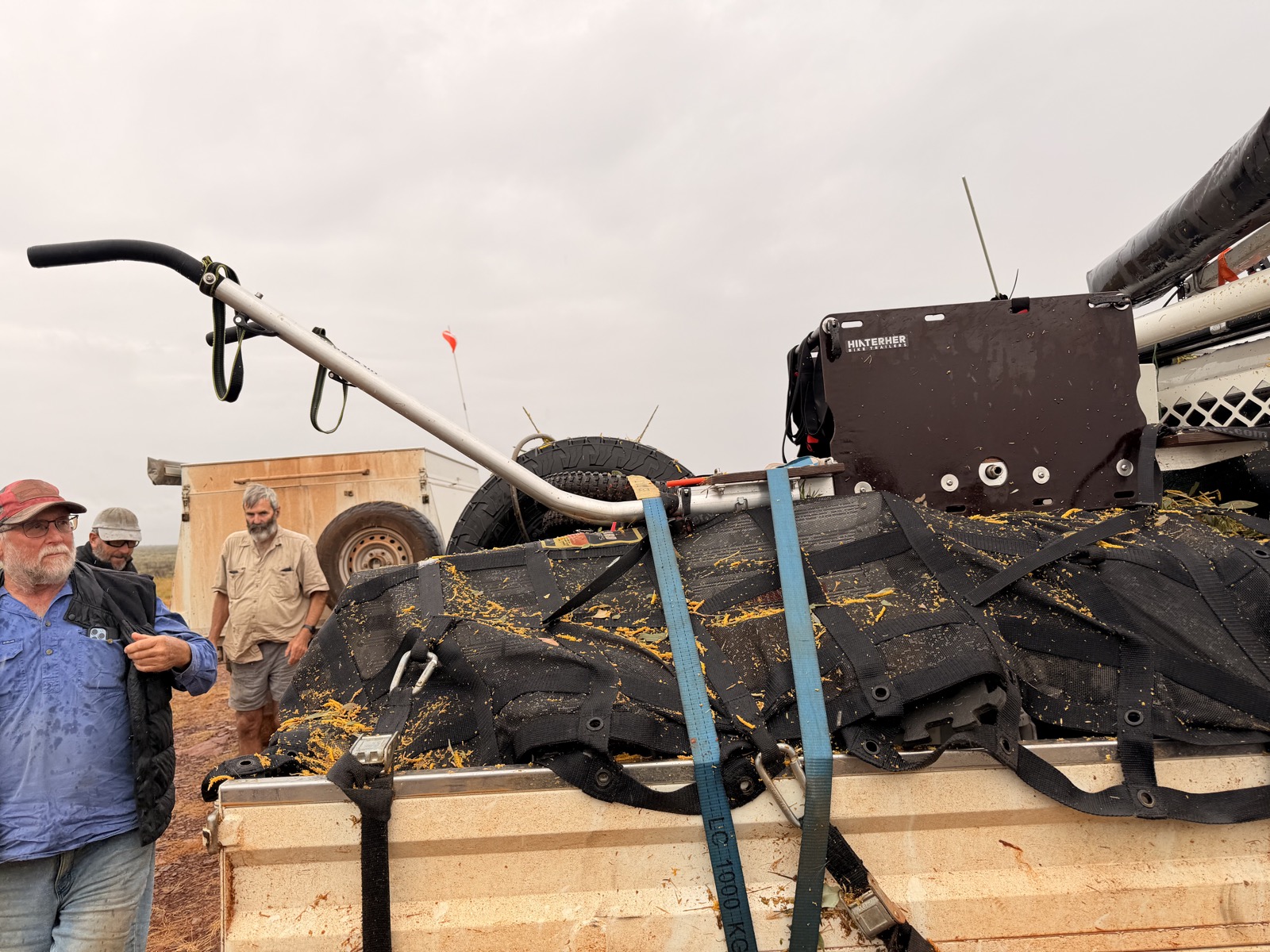 The trolley strapped to a trailer, caked in mud and spinifex